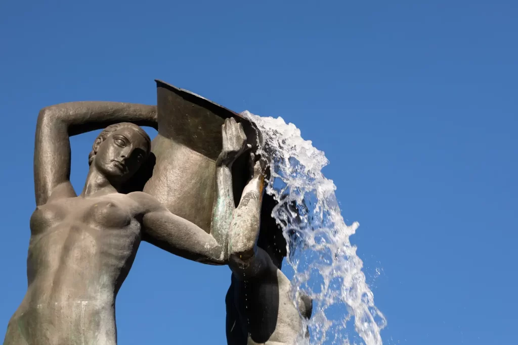 Dettaglio della Fontana Luminosa di L'Aquila. Ci sono due statue che reggono un'anfora con l'acqua che cade
